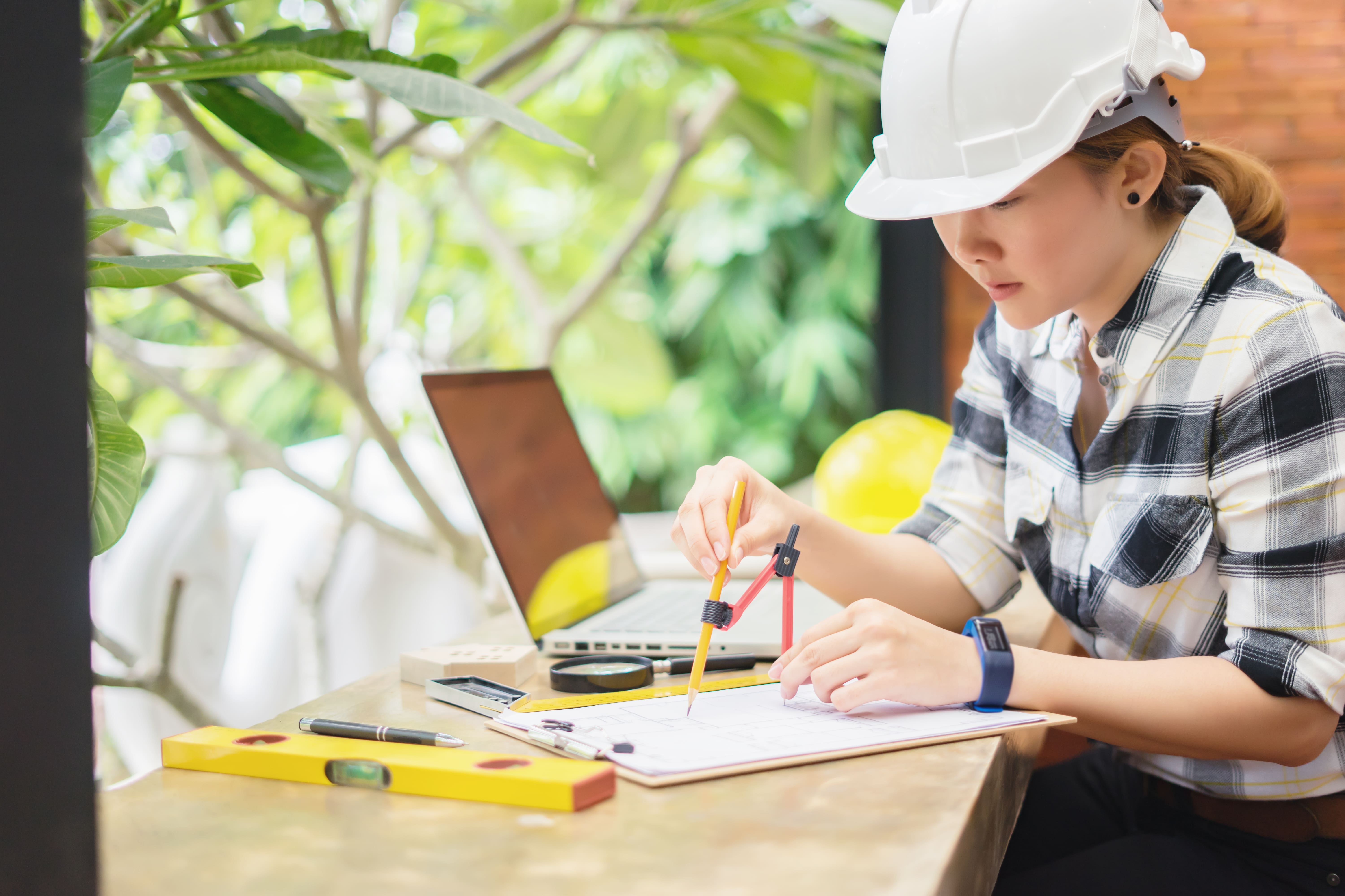 woman in hardhat working at a table woman in hardhat working at a table
